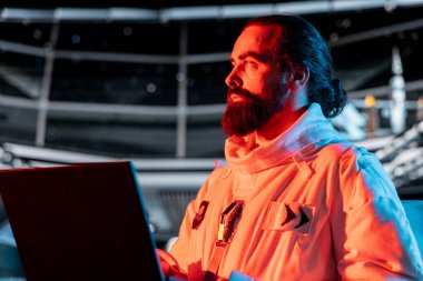 Astronot, yörünge istasyonundaki sistem hatasından kaynaklanan kırmızı ışık uyarısını sorun yaratmak için defter üzerinde çalışır. Uzay gemisi mürettebatı operasyonları etkileyen arızayı araştırmak için aygıt kullanıyor