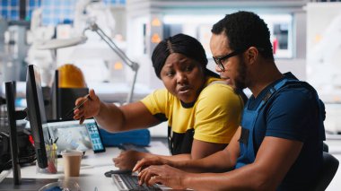 Çalışanlar, temiz enerji santralindeki fotovoltaik tasarım güncellemeleri üzerinde çalışarak, güneş paneli fabrikasındaki operasyonel verimliliği azaltmaya çalışıyorlar. Siyahi mühendisler teknik sorunları hallediyor. Kamera A.