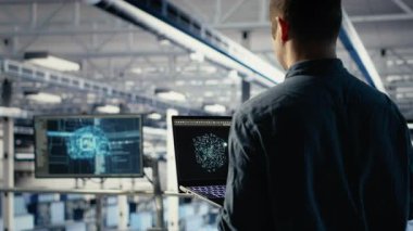 Veri merkezindeki yazılım geliştiricisi, rutin sistem incelemesi sırasında dizüstü bilgisayarı kullanarak Al 'ın gösterge panelini kontrol ediyor. Sunucu merkezi IT uzmanı performansı kontrol etmek için yapay zekayı not defterinde test ediyor, kamera B