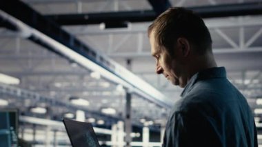 Teknisyen tesiste yürürken laptop kullanarak sunucu odası aktivitelerini izliyor. Veri Merkezi IT profesyonel incelemeleri sistemlerin doğru çalıştığından emin olmak için test sonuçları, kamera B