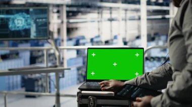 Veri merkezi çalışanlarını kapatın. Sistem incelemesi sırasında yeşil ekran tableti kullanarak Al 'ın gösterge panelini kontrol edin. Sunucu merkezi çalışanları yapay zeka araçlarını güvenilir performans için modelleme aygıtı üzerinde test ediyor