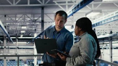 Mühendislerden oluşan bir ekip sunucu merkezinin faaliyetlerini dizüstü bilgisayar ve tablet kullanarak takip ediyor. Takım çalışması veri merkezi meslektaşları sistemlerin düzgün çalıştığından emin olmak için araçlar üzerindeki test sonuçlarını gözden geçirin, kamera B