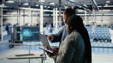 Sunucu odasında birlikte çalışan teknisyenler, yapay zeka sistemlerinin görevlerini en iyi şekilde yapmalarını sağlıyorlar. Veri Merkezi çalışanları yapay zeka model parametrelerini ayarlamak için beyin fırtınası yapıyorlar, kamera B