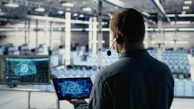 Veri merkezi mühendisi, müşterilerin web sitesi sunucu sorunlarını çözmek için tablette yapay zeka kullanıyor. Sunucu merkezi teknik destek uzmanı kullanıcıların çevrimiçi servislerini sorunsuz çalıştırmalarına yardımcı oluyor, kamera B