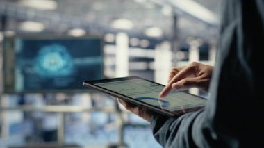 Sunucu odası çalışanı sistem sağlığını izlemek için tabletteki veri tabletlerini kontrol ediyor. Sistem yöneticisi veri merkezinin iş hedefleri ve müşteri ihtiyaçları olan kamera B 'yi karşıladığından emin olmak için grafikleri gözden geçirir