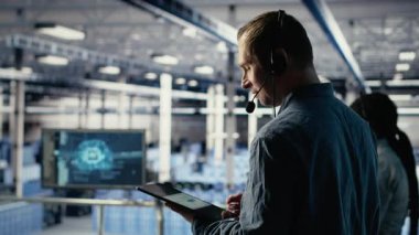 Veri merkezi yöneticisinin ses mikrofonuyla konuşması, müşterilerin web sitesi sunucu sorunlarını çözmesine yardımcı oluyor. Endüstriyel platformdaki sunucu tarım işçisi kullanıcıların çevrimiçi hizmetleri sürdürmelerine yardımcı oluyor, kamera B