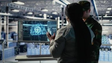 Sunucu odasındaki ordu uzmanları keşif bilgilerini incelemek için yapay zeka programı kullanıyorlar. Askeri veri merkezi meslektaşları görevleri hazırlamak için makine öğrenme sistemleri çalıştırıyorlar, kamera B