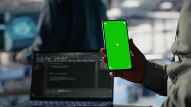 Mühendis, derin öğrenme sistemlerini optimize ederken sunucu odasında izole ekran akıllı telefonu kullanıyor. Veri merkezi çalışanı krom anahtar cep telefonu kullanıyor, Yapay zeka model parametrelerini ayarlıyor, kamera B