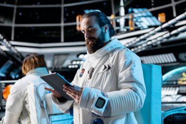 Kozmonot yıldız ve asteroit desenleri dışarıda yapılacak gezegen görevine hazırlanıyor. Galaksi görselleştirmesine bakan astronot, güneş sistemi gezegenine iniş prosedürlerini başlatıyor.