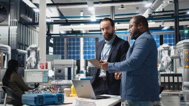 Çeşitli mühendisler ve uzmanlar bir güneş paneli fabrikasında işbirliği yapar, planları gözden geçirir ve yenilenebilir enerji üretimini ve sürdürülebilir yenilikleri geliştirmek için fikirlerini paylaşırlar. Kamera A.