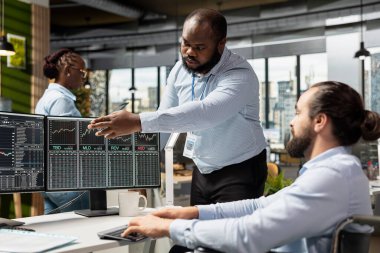 Felçli yönetici ve paraplejik adam malzeme firmasında PC 'de ticaret uygulaması kullanarak ticaret yapıyorlar. Tekerlekli sandalyede engelli ekip lideri ve kişi borsa verilerini izliyor.
