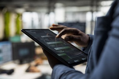 Siyahi analistin tabletle ilgili bilgi grafikleri raporlarını doğrulaması, iş yönetimi ve büyüme için teknolojiyi kullanması. Şirket sektöründe başarı tahminleri geliştiriliyor.