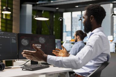 Ofisteki yazılım geliştiricisi kritik hata uyarıcısına şaşırdı ve düzeltmeye çalıştı. PC ekranında sorun çıkaran Afrikalı Amerikalı adam bildirimi iş akışını kesiyor