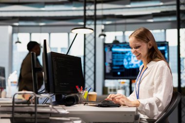 Neşeli küçük dev kod yazma, makine öğrenme API 'leri geliştiriyor. Ofiste çalışan mutlu genç bayan mühendis, yapay zeka teknolojisi kullanan yazılım hataları.