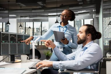 Prop firmasının iş arkadaşları, daha iyi sonuçlar elde etmek için pazardaki verileri birlikte analiz ederek, ofiste ticaret stratejileri üzerinde işbirliği yapıyorlar. Komisyoncu meslektaşlar yeni fırsatları ve pazar eğilimlerini tartıştılar