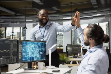 Borsa analizi için yapay zekayı kullanarak para kazandıktan sonra mutlu tüccarlar beşlik çakıyor. Komisyoncu iş arkadaşları, borsayı izlemek için makine öğrenme analizlerini birleştirdikten sonra kutlama yapıyorlar