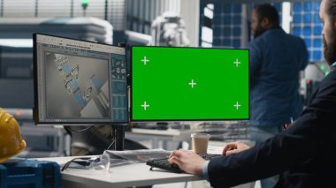 Sürdürülebilirlik uzmanı, modern bir endüstriyel tesiste üretim bandı üzerinde çalışan güneş paneli sistemlerini modellemenin yanında değerlendiriyor. Temiz enerji verimliliği için yönlendirme operasyonları. Kamera B.