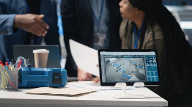 Afro-Amerikan üretim uzmanları yenilenebilir enerji ve endüstriyel işlemler için üretim hattının geliştirilmesini planlamak üzere bir güneş enerjisi santralinde toplandılar. Kamera B.