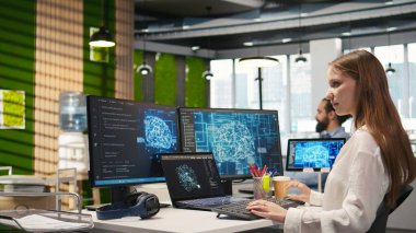 Ofisteki küçük dev yapay zeka teknisyenine birden fazla cihazda görev yapması ve ekranlardaki ilerlemeyi izlemesi için güveniyor. Genç işçi yapay zeka modelleri geliştirmek için sinirsel ağlar kullanır, kamera A