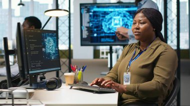 Performans ve hava tahminlerini optimize etmek için yapay zeka kullanan kadın yazılım geliştirici. Ofis eğitim makinesindeki kadın modelleri bilgisayar, kamera A kullanarak öğreniyor.