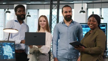 Ofisteki takım çalışması programcılarının portresi yapay zeka otomasyonunu kullanarak uygulamalar geliştiriyor. Gülümseyen bilişim uzmanlarından oluşan bir ekip aygıtlar üzerinde çalışıyor, yapay zekayla hata ayıklama uygulamaları, kamera A