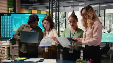 Çok ırklı kadınlar, başarı, ilerleme ve ortak hedefler etrafında sıralanmış performans verilerini ve belgeleri analiz ederek iş stratejisini tartışan güçlü bir ekip oluştururlar. Kamera A.