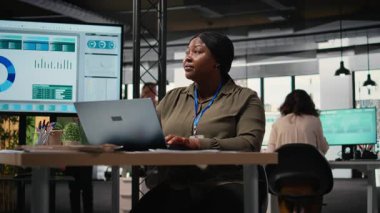 Siyahi şirket yöneticisi belgeleri gözden geçirir ve stratejiyi ayarlar, kilit verileri bilgisayarına aktarır. Proje geliştirme ve tamamlama için kaynak tahsis ediliyor. Kamera A.