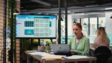 Modern girişimci proje analizlerini ve dizüstü bilgisayarındaki ilerlemesini inceleyerek çalışma yerinde stratejik bir rapor hazırlıyor. Verimlilik ve kariyer geliştirme eylemi gösteriyor. Kamera A.