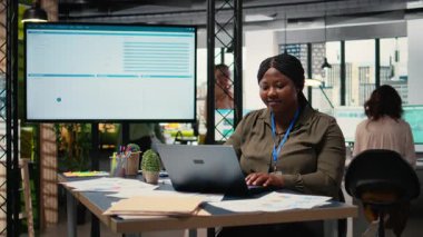 Finansal verileri analiz eden ve parlak bir ofiste raporlar yazan iş danışmanı, finansal durumu grafikler ve dizüstü bilgisayardaki öngörülerle değerlendirerek şirketin faaliyetini geliştirdi. Kamera A.