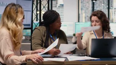 Çeşitli kadın gruplarının yeni bir strateji için biraraya gelmesi ve bilgi alışverişinde bulunması, ofisteki belgelerdeki çizelgeleri gözden geçirmesi. Hedefe yönelik güçlendirilmiş ortam, kurumsal feminizm. Kamera B.