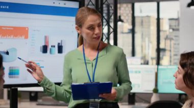 Hırslı iş hedefleri ve büyüme stratejisi sunan kadın CEO hissedarlar ve ortaklarla beyin fırtınası oturumuna giriyor. Ofisteki kurumsal feminizmi simgeliyor. Kamera B.