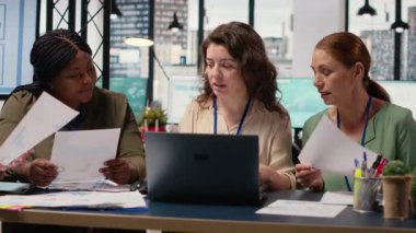 Brifing sırasında işbirliği yapan, veri analizi yapan ve raporlar yazan bir grup iş kadını bir büyüme zihniyetini benimserler. Hedefe yönelik toplantı. Kamera B.