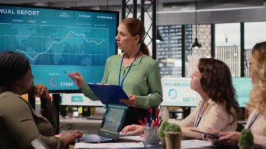 Profesyonel yönetici, şirket hedeflerini sunmak ve ekip üyeleriyle birlikte bir kalkınma stratejisi oluşturmak amacıyla bir toplantıya ev sahipliği yapıyor. Hedefe yönelik hırslı kadın lider. Kamera B.