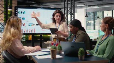 Geliştirme hedefleri olan bir proje planlayan yetkili iş ortakları, çok uluslu şirket büyümesine ilişkin veri içgörüleri ve performans göstergelerini gözden geçirmek üzere bir toplantı odasında bir araya geliyorlar. Kamera A.