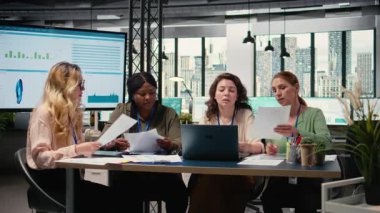 Çok ırklı hedef odaklı kadın takımı, veri analizi ve raporlarla yönetim kurulu planlamasında işbirliği yaparak liderliğin gücünü gösteriyor. Modern çalışma ortamı. Kamera A.