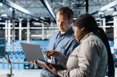 Sistem istikrarı için yazılım güncellemelerini yönetmek için dizüstü bilgisayar kullanan veri merkezi yöneticileri. Ekip çalışması sunucu odası bilişim uzmanları performansı cihazla optimize ediyor, altyapıyı yapılandırıyor