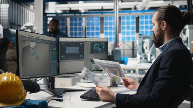 Erkek endüstriyel uzmanlar modern ekipman ve performans ölçümleriyle yüksek teknoloji üretim hattını, temiz enerji üretim operasyonlarını izliyorlar. Genç iş analisti mühendis. Kamera A.