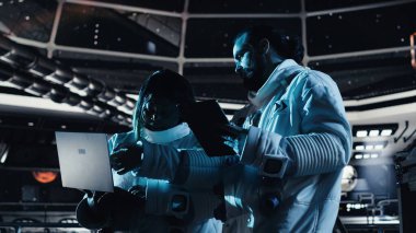 Astronot yörünge yolunu gösteren arayüze bakıyor, uzay görevi sırasında iş arkadaşıyla sohbet ediyor. Ekip halinde çalışan kozmonotlar, insanoğlunun hayatta kalma mücadelesi sırasında sorun çıkaran donanımlar.