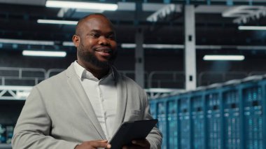 Verimli veri analizi için sunucu çiftliğinde yürüyen bir sistem yöneticisi. Veritabanları için depolama sistemlerini yöneten bir merkezde aygıt kullanan işçiler, kamera B