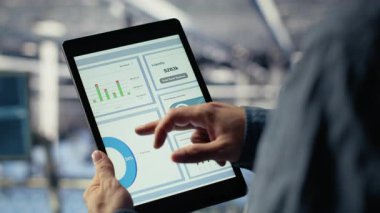 Veri merkezi çalışanlarını kapatın tablet ekrandaki altyapı grafiklerini kontrol edin. Sistem denetimi sırasında veri grafiklerini inceleyen sunucu odasındaki endüstriyel platform bilişim uzmanı, kamera B