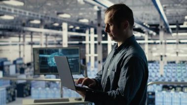 Veri merkezindeki mühendis, rutin sistem incelemesi sırasında dizüstü bilgisayarı kullanarak Al 'ın gösterge panelini kontrol ediyor. Bilişim uzmanı güvenilir performansı doğrulamak için not defterinde yapay zeka araçlarını test ediyor. Kamera B