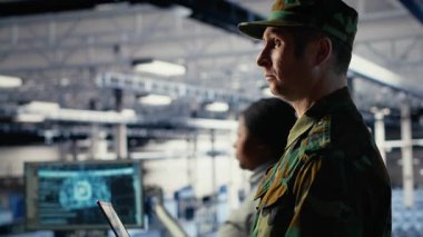 Sunucu merkezindeki ordu yazılım geliştiricisi keşif bilgilerini incelemek için dizüstü bilgisayarda yapay zeka uygulaması kullanıyor. Askeri veri merkezi çalışanı görevi planlamak için sinirsel ağlar kullanır, kamera B
