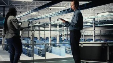 Sunucu merkezi bilişim uzmanı müşterilere hayati önem taşıyan şirket bilgilerini korumak için güvenli veri yedekleri kurma konusunda rehberlik ediyor. Veri merkezi çalışanı, sunuculardaki sistem hatalarını düzeltmeye yardımcı olur, kamera A