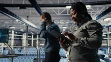 Sunucu merkezi teknik destek uzmanı şirket müşterilerine güvenli veri yedekleri kurma konusunda rehberlik ediyor. Veri merkezindeki Afrikalı Amerikalı kadın kullanıcıların sunuculardaki ve kamera A 'daki sistem hatalarını düzeltmelerine yardım ediyor