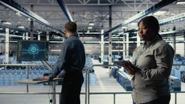 Veri merkezi teknisyenleri sistem incelemesi sırasında dizüstü bilgisayarı kullanarak Al 'ın gösterge panelini kontrol ediyor. Takım çalışması sunucu merkezi meslektaşları yapay zeka araçlarını test ediyor. Not defteri, kamera A