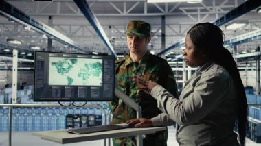 Veri merkezindeki askeri uzmanlardan oluşan bir ekip ekrandaki dünya haritasına bakıyor ve görev bölgelerini koordine ediyor. Sunucu merkezindeki ordu arkadaşları savaş alanı operasyonlarını planlamak için küresel haritaya bakıyor, kamera A