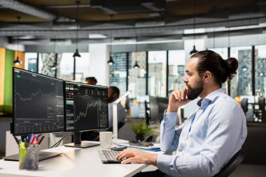 Pazardaki verileri analiz eden ve PC 'deki ticari yazılım arayüzünü kullanarak alım satım işlemlerini yürüten bir borsa simsarı. Varlık yönetimi şirketinde çalışan borsacı bilgisayar kullanarak hisse senedi fiyatlarını izliyor