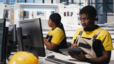 PC tabanlı güneş teknisyeni üretim fabrikasındaki otomasyon verilerini inceledi, üretim endüstrisi yenilenebilir enerjiye odaklandı. İşçi güneş panellerini ve makine performansını izliyor. Kamera B.