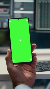 Dikey video Equity analisti, hisse senedi piyasa değerini değerlendirmek için üç aylık kazançları gözden geçirmek üzere yeşil ekran akıllı telefonu kullanıyor. Tüccar geliştirmek için model cep telefonu kullanarak finansal analiz yürütüyor