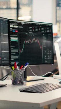 Özel firma ofisinde borsa grafiklerini gösteren dikey video ekranlar. Borsa analizi ve strateji planlaması için kullanılan komisyon işi çalışma masası kurulumu
